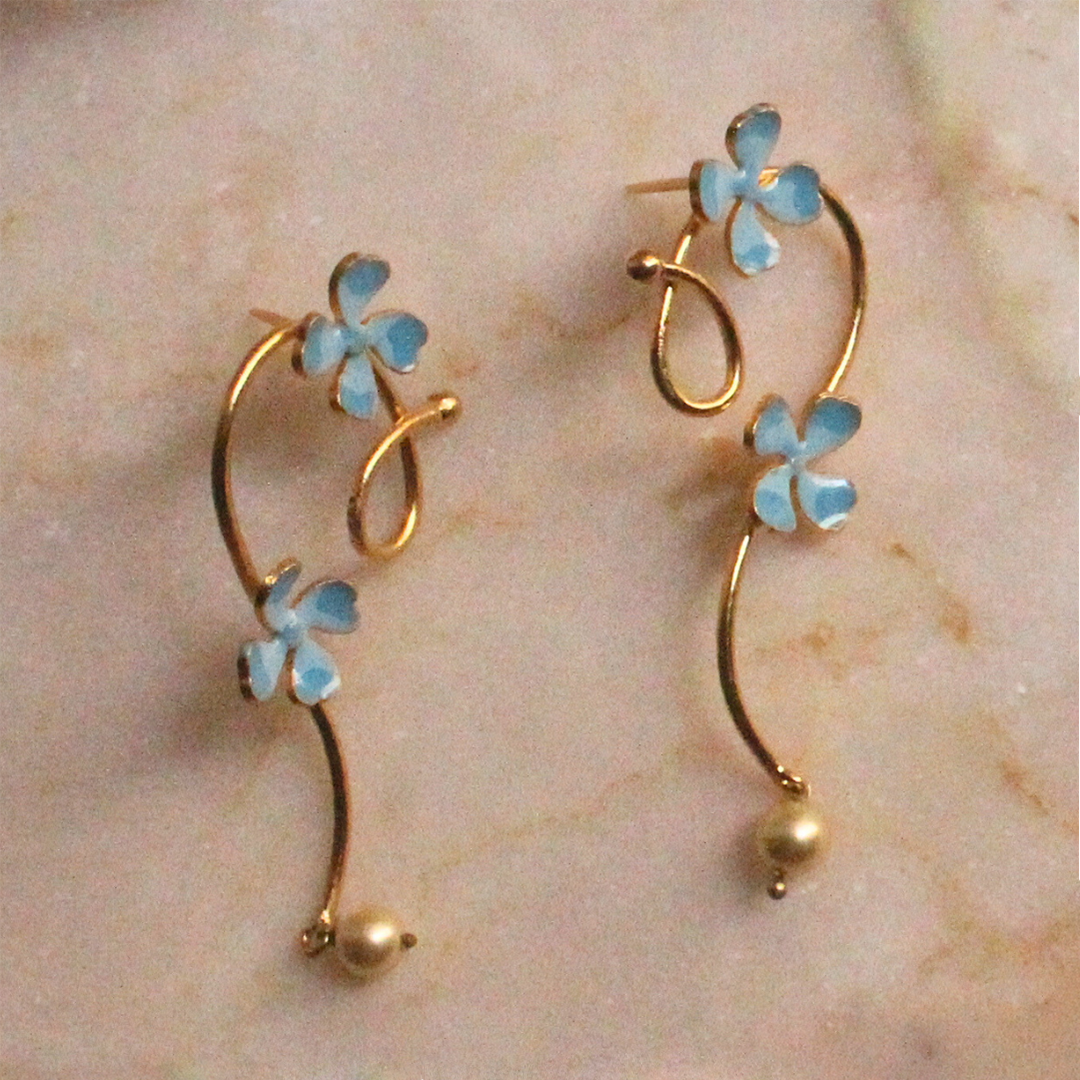 Pair of gold curl earrings adorned with soft blue enamel flowers and small pearl-like drops