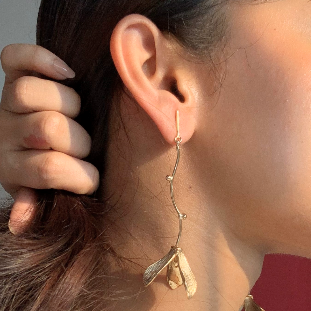 Hanging flower earrings with matte-gold petals and flowing vine stems, made from brass and 18K rhodium gold plating