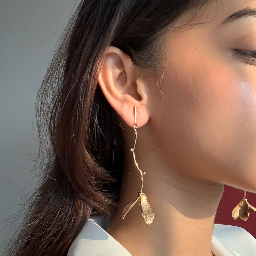 Hanging flower earrings with matte-gold petals and flowing vine stems, made from brass and 18K rhodium gold plating