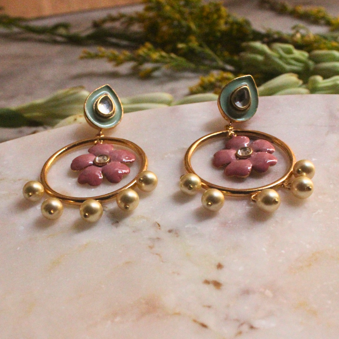 Pair of Gulbahar Enamel Meena Earrings featuring hand-painted pink enamel flowers inside golden hoops, adorned with faux pearl drops and pastel teardrop studs with kundan-style accents