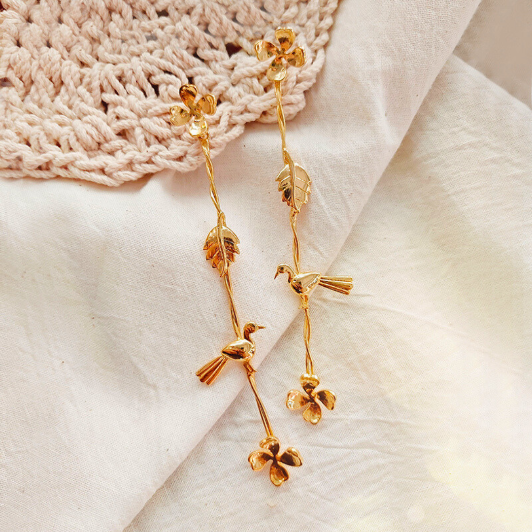 Gold Plated Long Dangler Earrings Featuring Delicate Twisted Stems, Floral Motifs, Textured Leaves, and Small Perched Birds