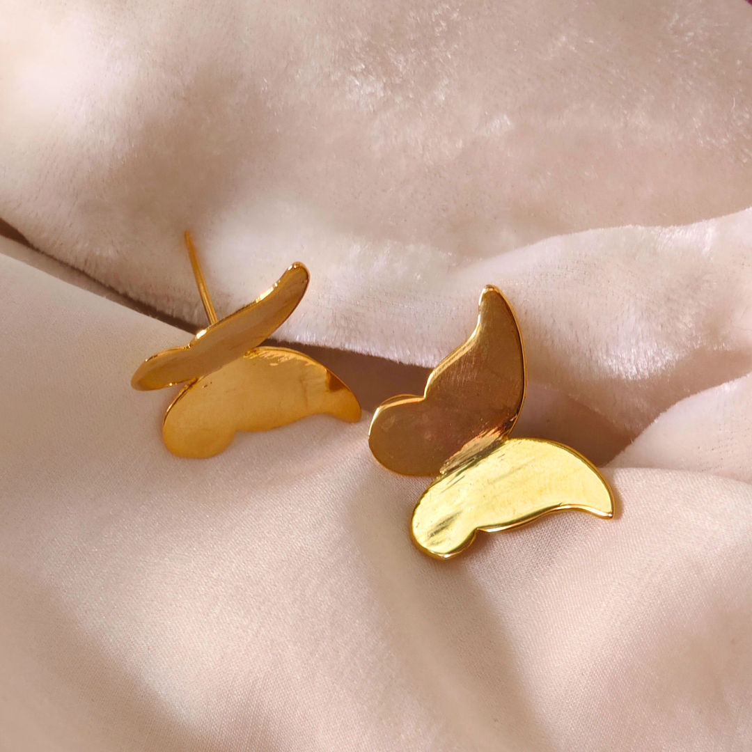 A pair of Gold Plated Butterfly Earrings featuring sleek, minimalist butterfly-shaped designs crafted from brass with a shiny 18k rhodium gold finish.