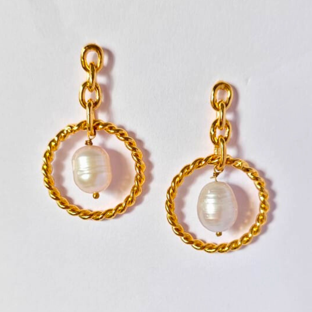 A pair of elegant dangle earrings featuring natural tumble pearl beads suspended in twisted gold-plated circular loops, connected by delicate gold chain links