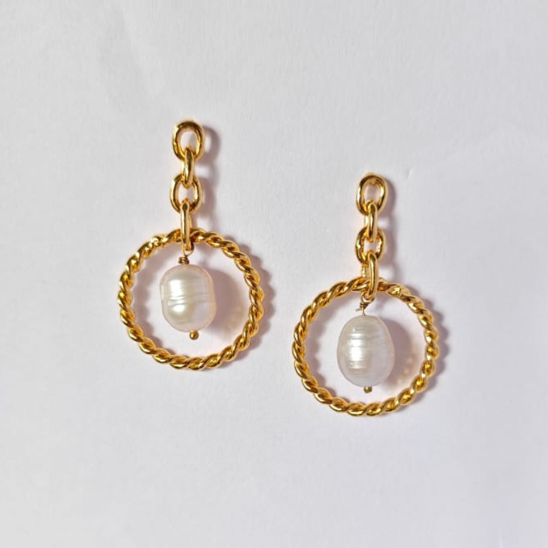 A pair of elegant dangle earrings featuring natural tumble pearl beads suspended in twisted gold-plated circular loops, connected by delicate gold chain links