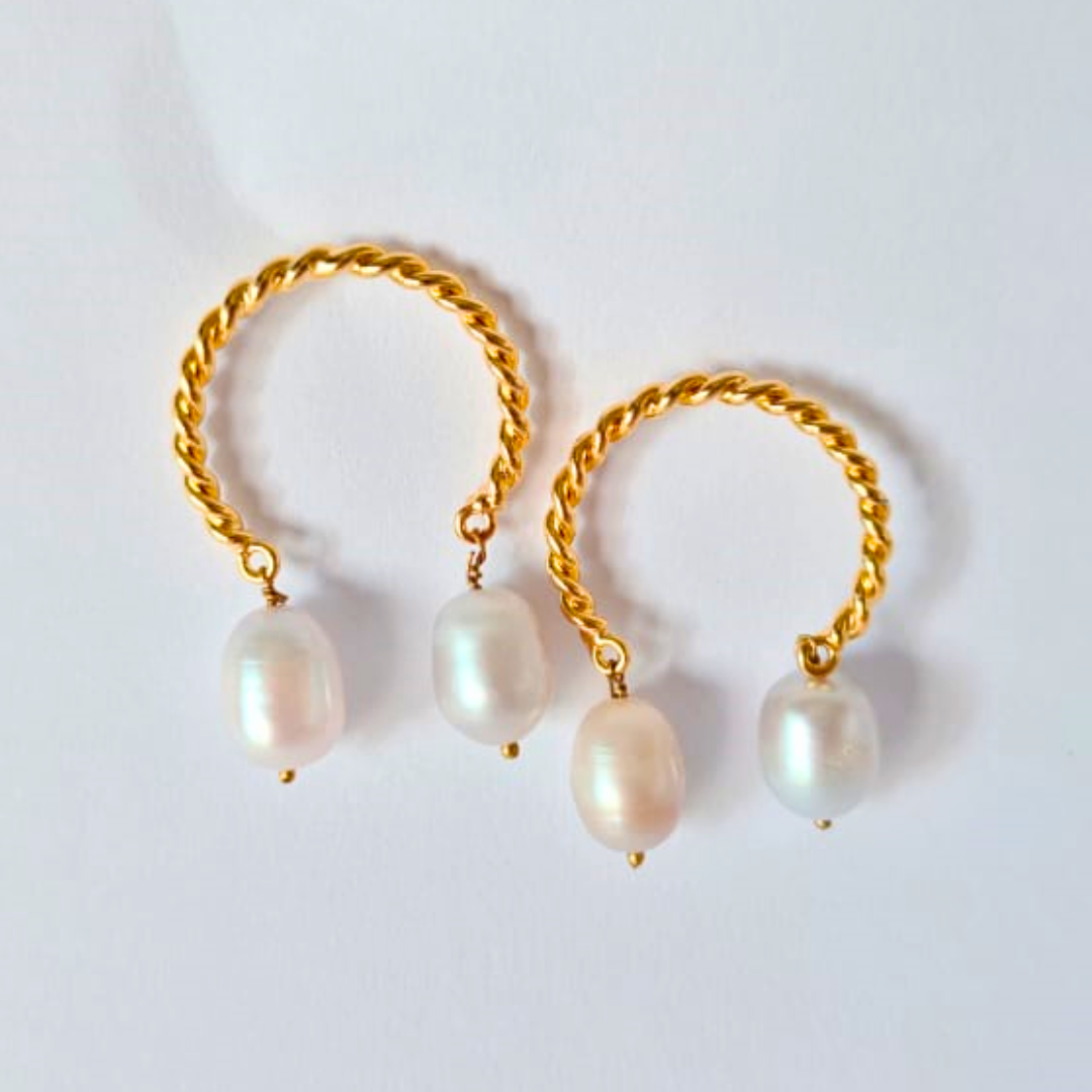 A pair of gold-plated twisted hoop earrings, each adorned with two natural white pearls hanging delicately from the bottom