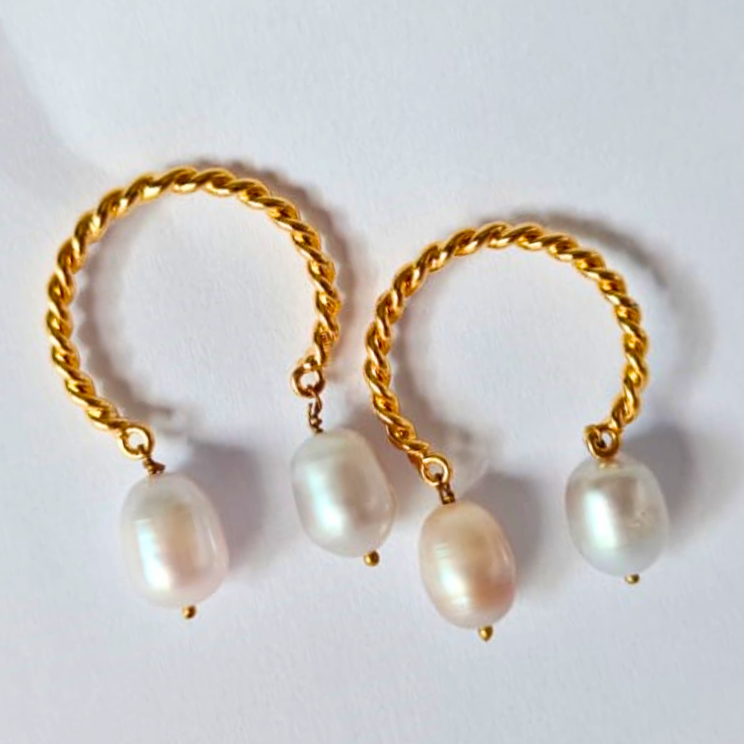 A pair of gold-plated twisted hoop earrings, each adorned with two natural white pearls hanging delicately from the bottom