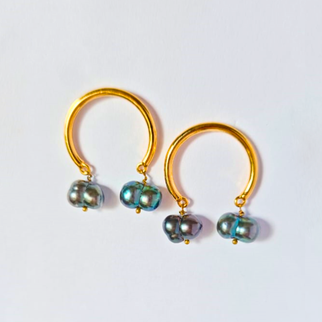 A pair of elegant earrings featuring smooth gold-plated hoops with two iridescent dark baroque pearls suspended from each