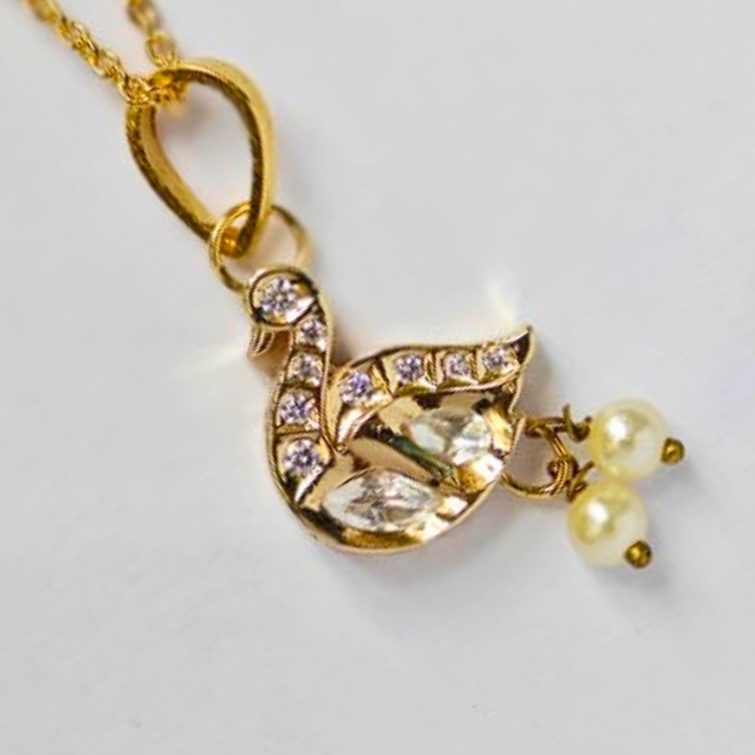Gold swan-shaped pendant adorned with Kundan stones and two hanging pearl drops