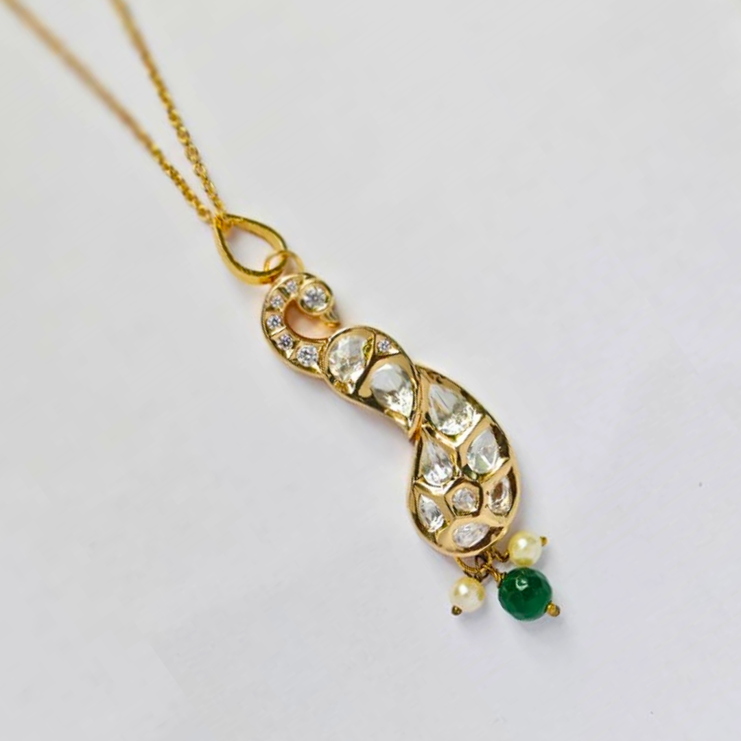 Handmade gold peacock-shaped pendant embellished with shimmering Kundan stones, featuring green and pearl bead drops