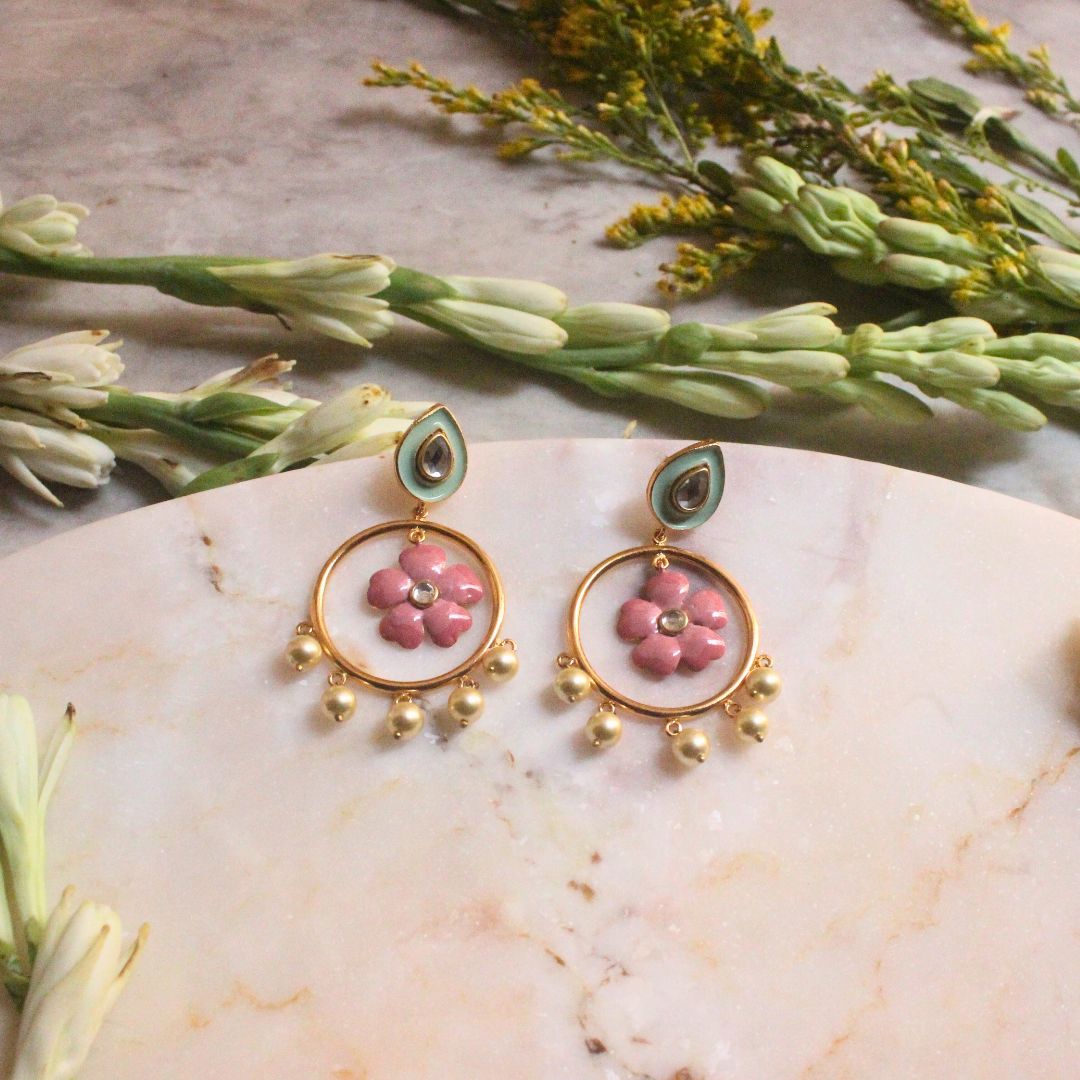 Pair of Gulbahar Enamel Meena Earrings featuring hand-painted pink enamel flowers inside golden hoops, adorned with faux pearl drops and pastel teardrop studs with kundan-style accents