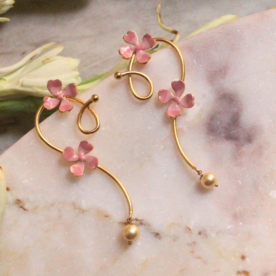 Pink Enamel Petal Curl Earrings with hand-enameled floral accents on gracefully curved gold-plated brass, ending in a single faux pearl drop