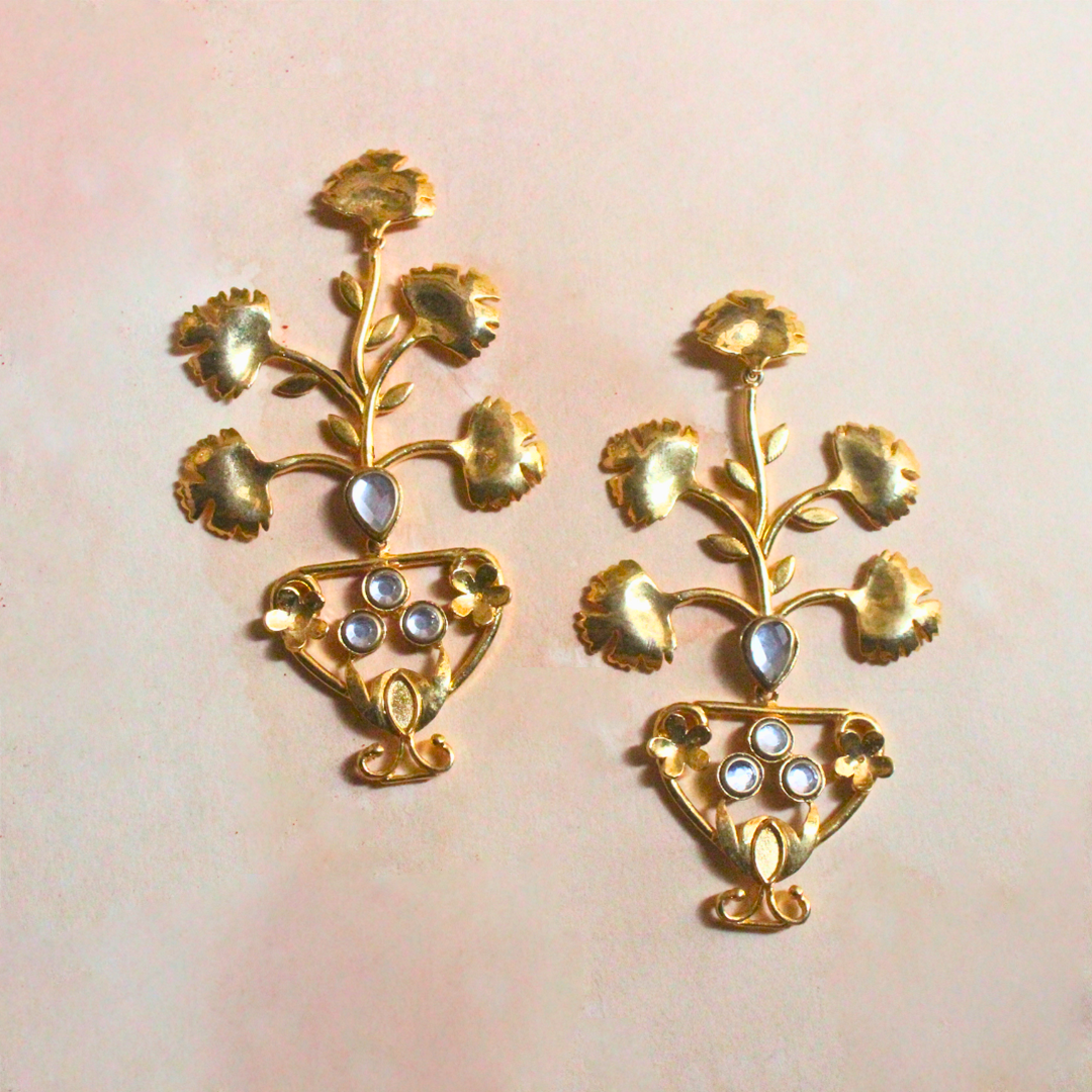 Pair of brass and 18k rhodium gold plated statement earrings with sculptural floral designs emerging from ornate urn-shaped bases, accented with luminous stones