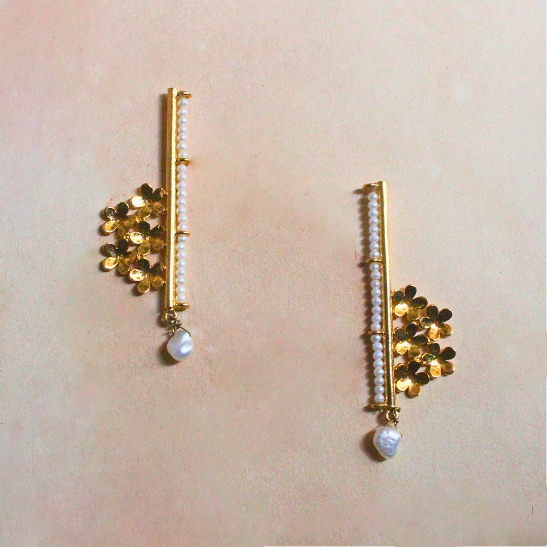 Handcrafted brass earrings with 18K rhodium gold plating, featuring golden floral clusters, a vertical row of faux pearl beads, and a single drop pearl