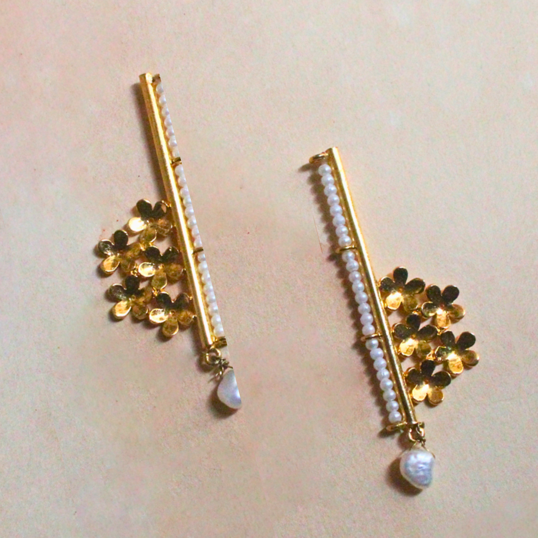 Handcrafted brass earrings with 18K rhodium gold plating, featuring golden floral clusters, a vertical row of faux pearl beads, and a single drop pearl