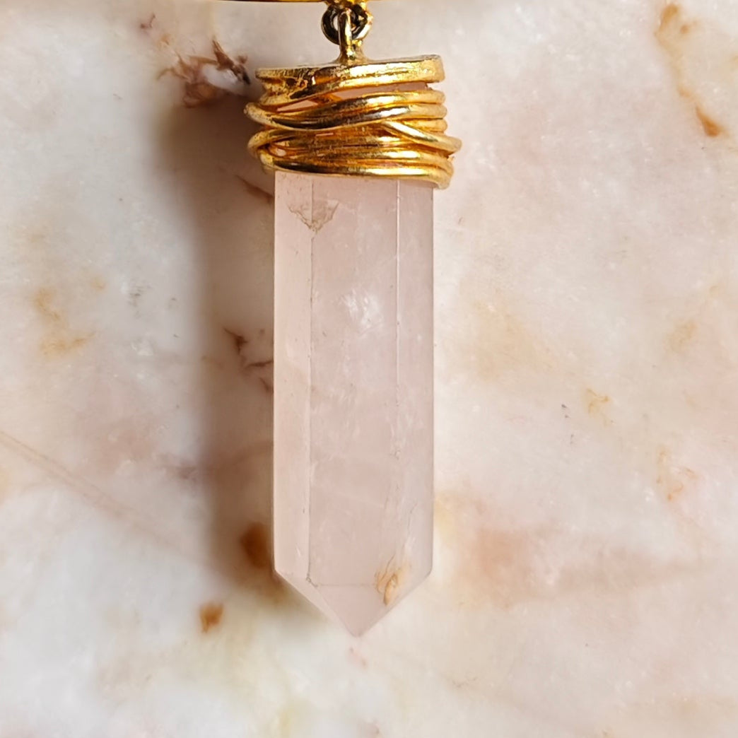 Necklace with a crystal pendant on a marble surface