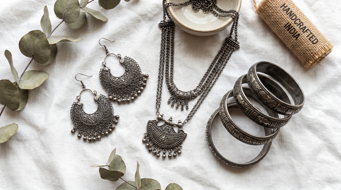 Oxidised silver jewellery flat lay with dark patina earrings and bangles on white linen – KANSYA Jewellery