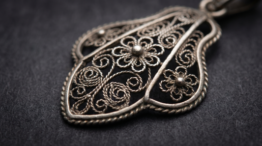 Macro of delicate silver filigree wire jewellery pendant with lace-like patterns – KANSYA Jewellery