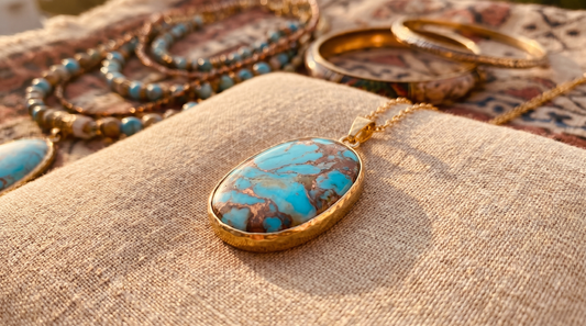Turquoise stone pendant necklace with gold bezel setting on sandy beige linen – KANSYA Jewellery