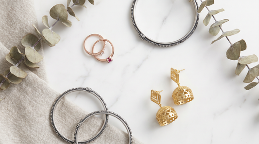 Mixed metal jewellery flat lay with rose gold rings, silver bangles and gold earrings on marble – KANSYA Jewellery