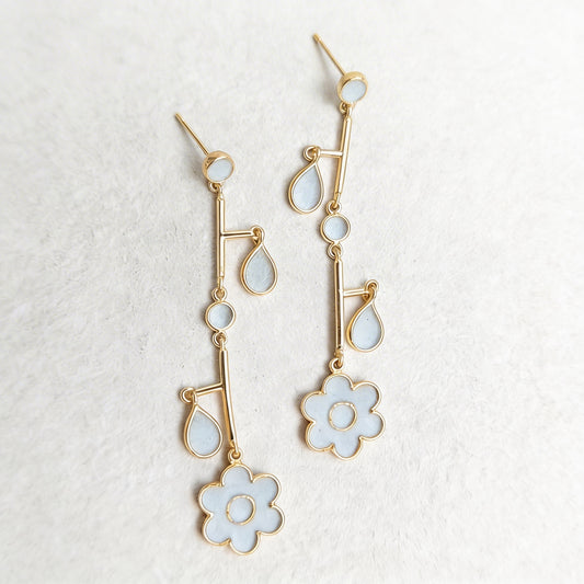 Gold and cement filled earrings on a textured white background