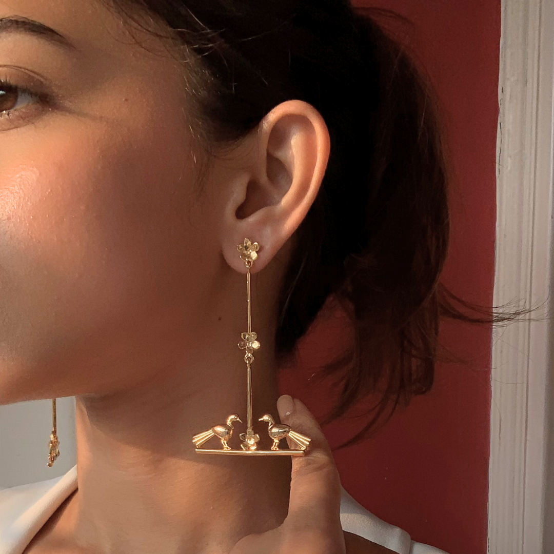 Nature-inspired Love Birds earrings with golden birds and flower accents, made of brass and rhodium gold