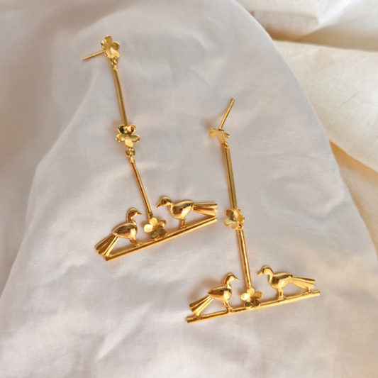 Nature-inspired Love Birds earrings with golden birds and flower accents, made of brass and rhodium gold
