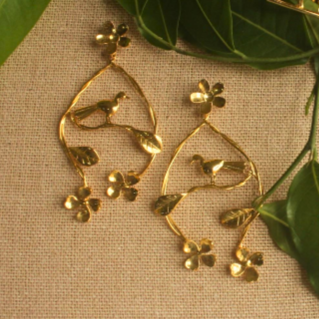 Handcrafted Nature's Embrace dangler earrings with flowers, leaves, and a resting bird, made from brass and 18K rhodium gold