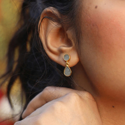 Close-up of an ear wearing gold cement drop earrings 