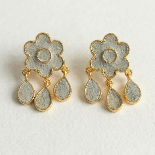 Pair of floral earrings with gold accents on a light gray background
