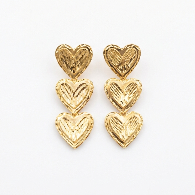 Gold heart-shaped earrings on a white background
