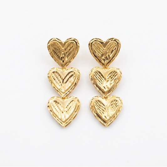 Gold heart-shaped earrings on a white background