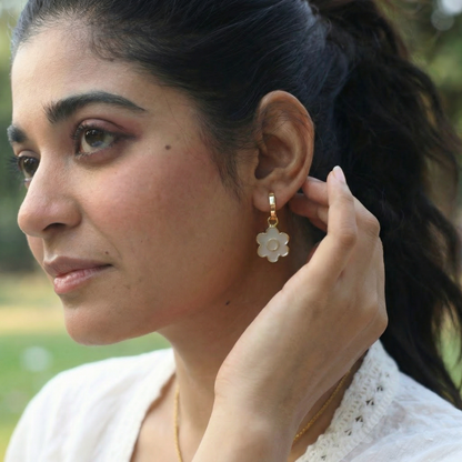 Woman adjusting a floral earring outdoors