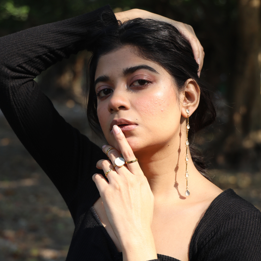 Model in shoulder touching cement earrings