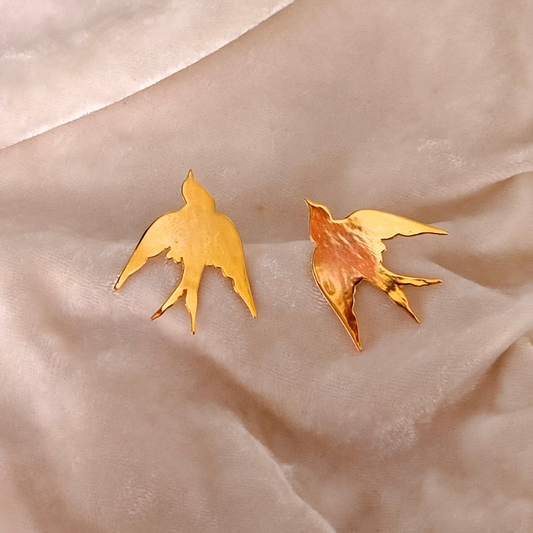 A pair of Gold Plated Flying Bird Earrings featuring elegant bird-in-flight silhouettes crafted from brass with a polished 18k rhodium gold finish.








