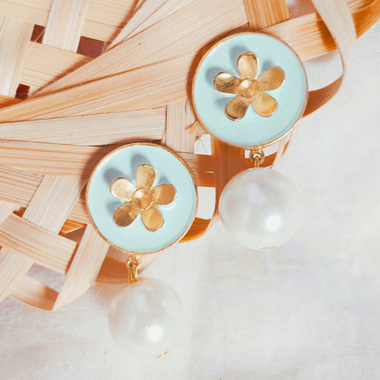 A pair of handcrafted earrings featuring sky blue Meena enamel discs with gold floral motifs and elegant faux pearl drops, set in 18K gold-plated brass.