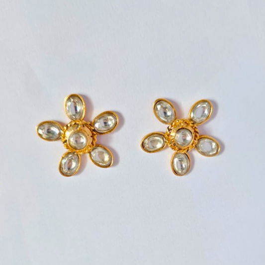 A pair of gold-plated floral stud earrings with six clear faux kundan stones arranged as petals around a central stone
