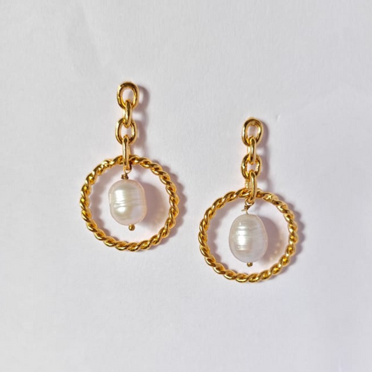 A pair of elegant dangle earrings featuring natural tumble pearl beads suspended in twisted gold-plated circular loops, connected by delicate gold chain links