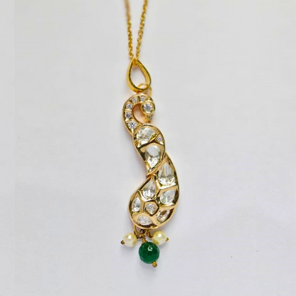 Handmade gold peacock-shaped pendant embellished with shimmering Kundan stones, featuring green and pearl bead drops