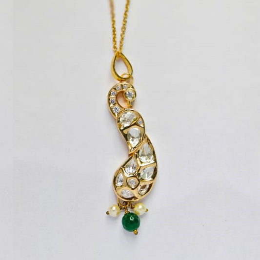 Handmade gold peacock-shaped pendant embellished with shimmering Kundan stones, featuring green and pearl bead drops