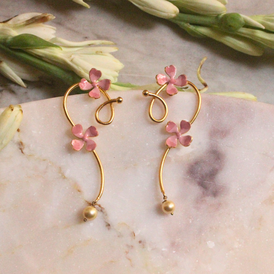Pink Enamel Petal Curl Earrings with hand-enameled floral accents on gracefully curved gold-plated brass, ending in a single faux pearl drop