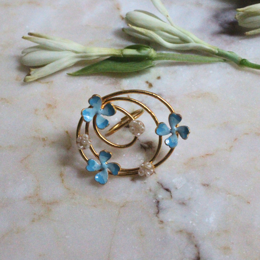 Elegant gold spiral ring with blue enamel flower blossoms and pearl-like accents