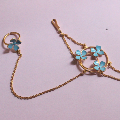 Handmade brass and 18k rhodium gold plated bracelet with fine chains connecting a circular floral motif of blue enamel flowers to a matching finger ring
