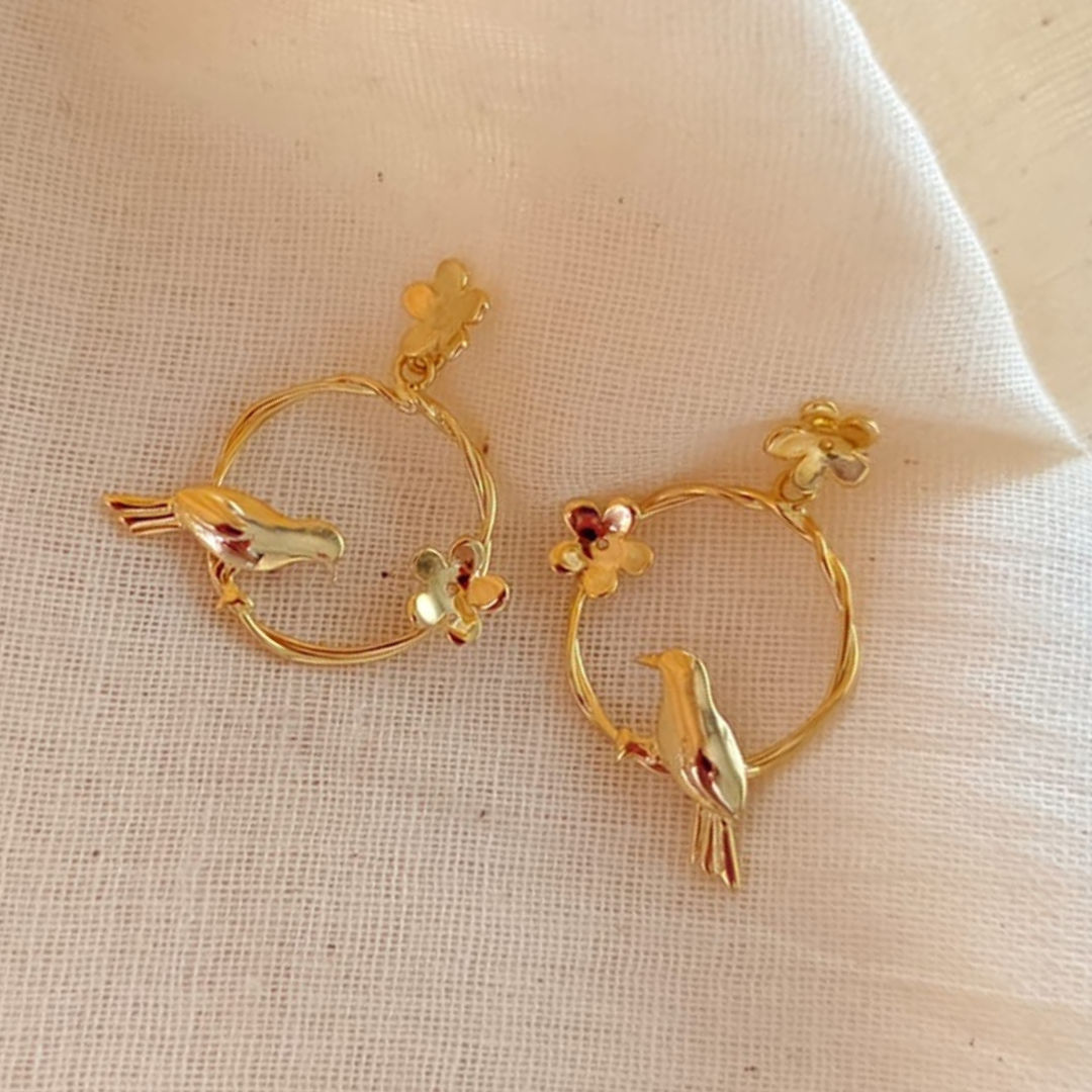 18K rhodium gold-plated earrings with sculpted bird on twisted hoop and floral accents, made in brass