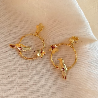 18K rhodium gold-plated earrings with sculpted bird on twisted hoop and floral accents, made in brass