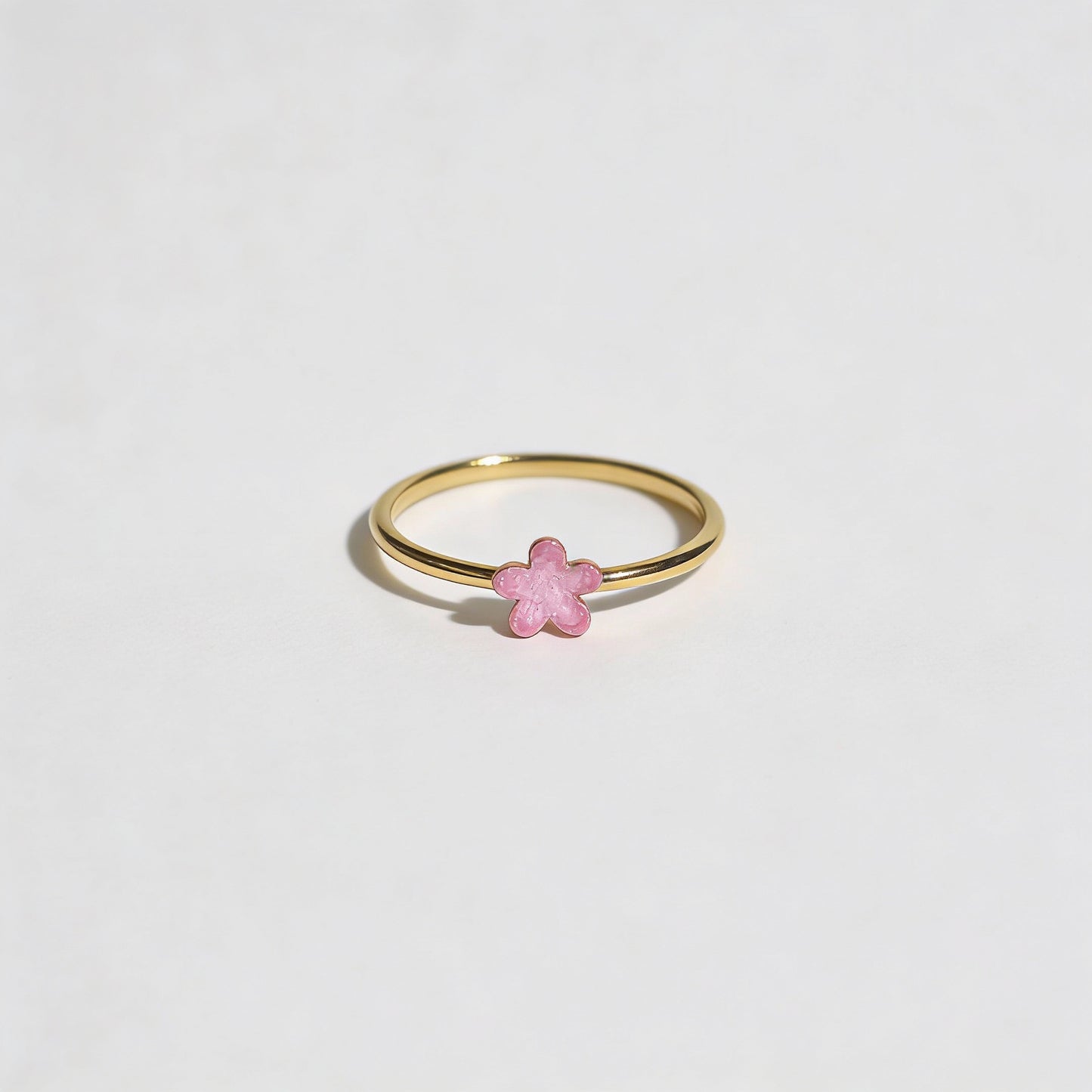 Gold ring with a pink enamel detailing on flower shape