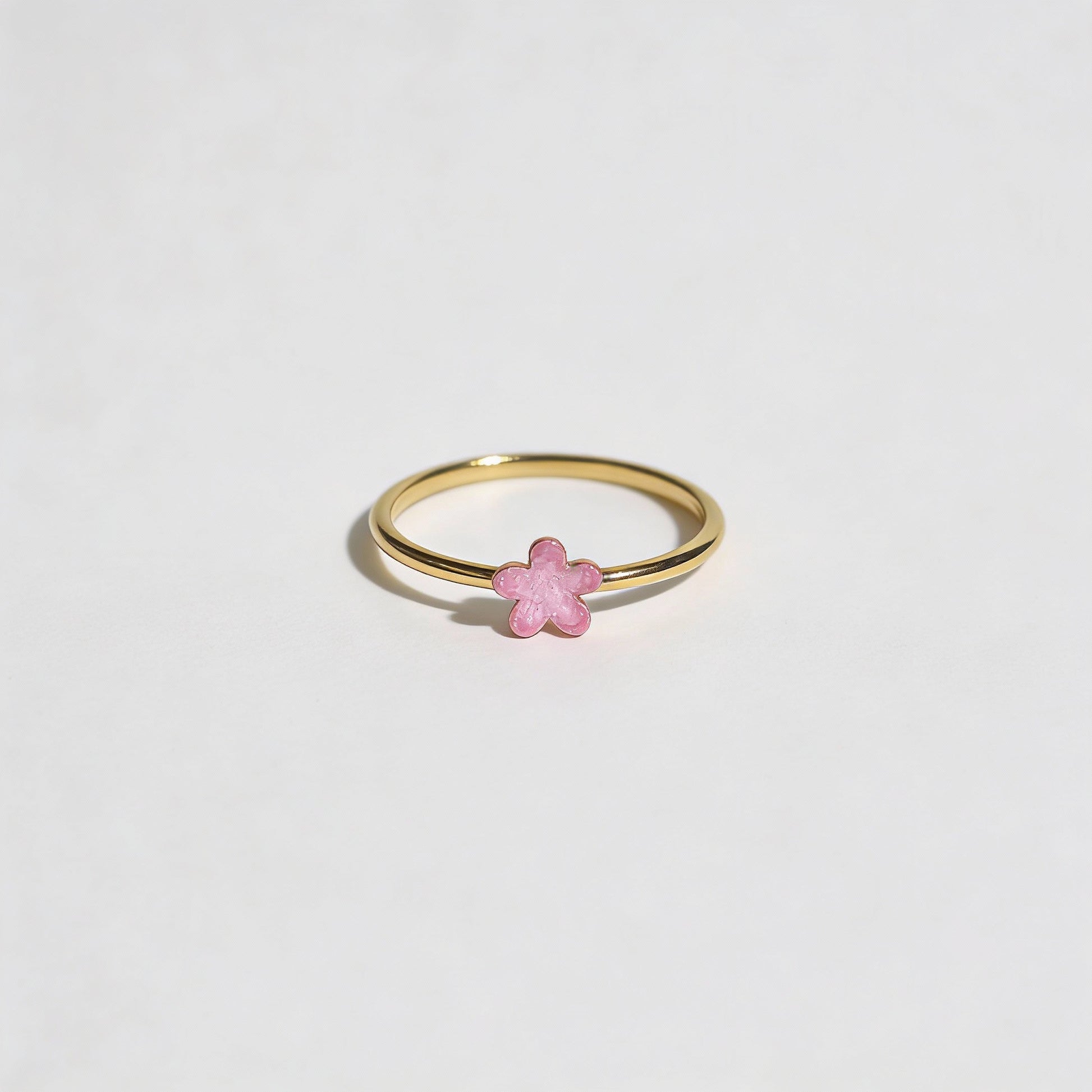 Gold ring with a pink enamel detailing on flower shape