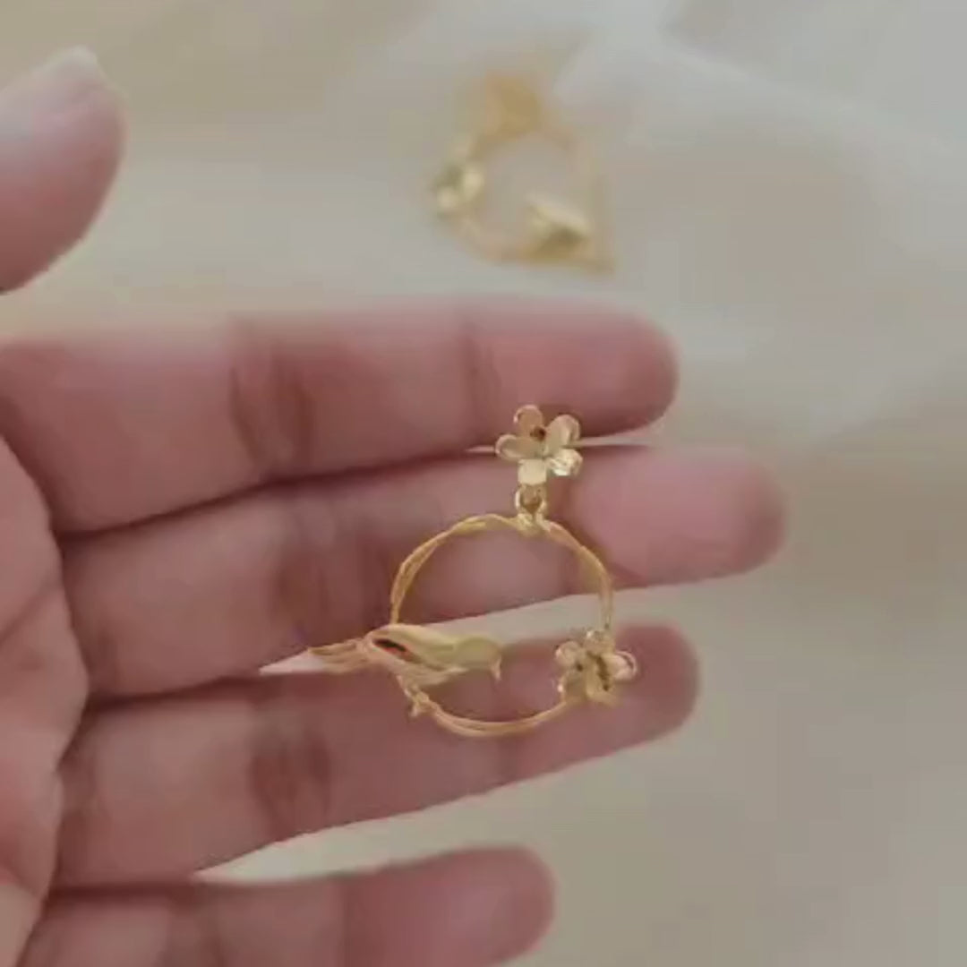 18K rhodium gold-plated earrings with sculpted bird on twisted hoop and floral accents, made in brass