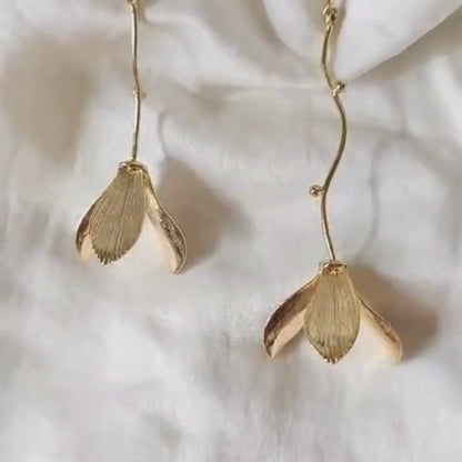 Hanging flower earrings with matte-gold petals and flowing vine stems, made from brass and 18K rhodium gold plating