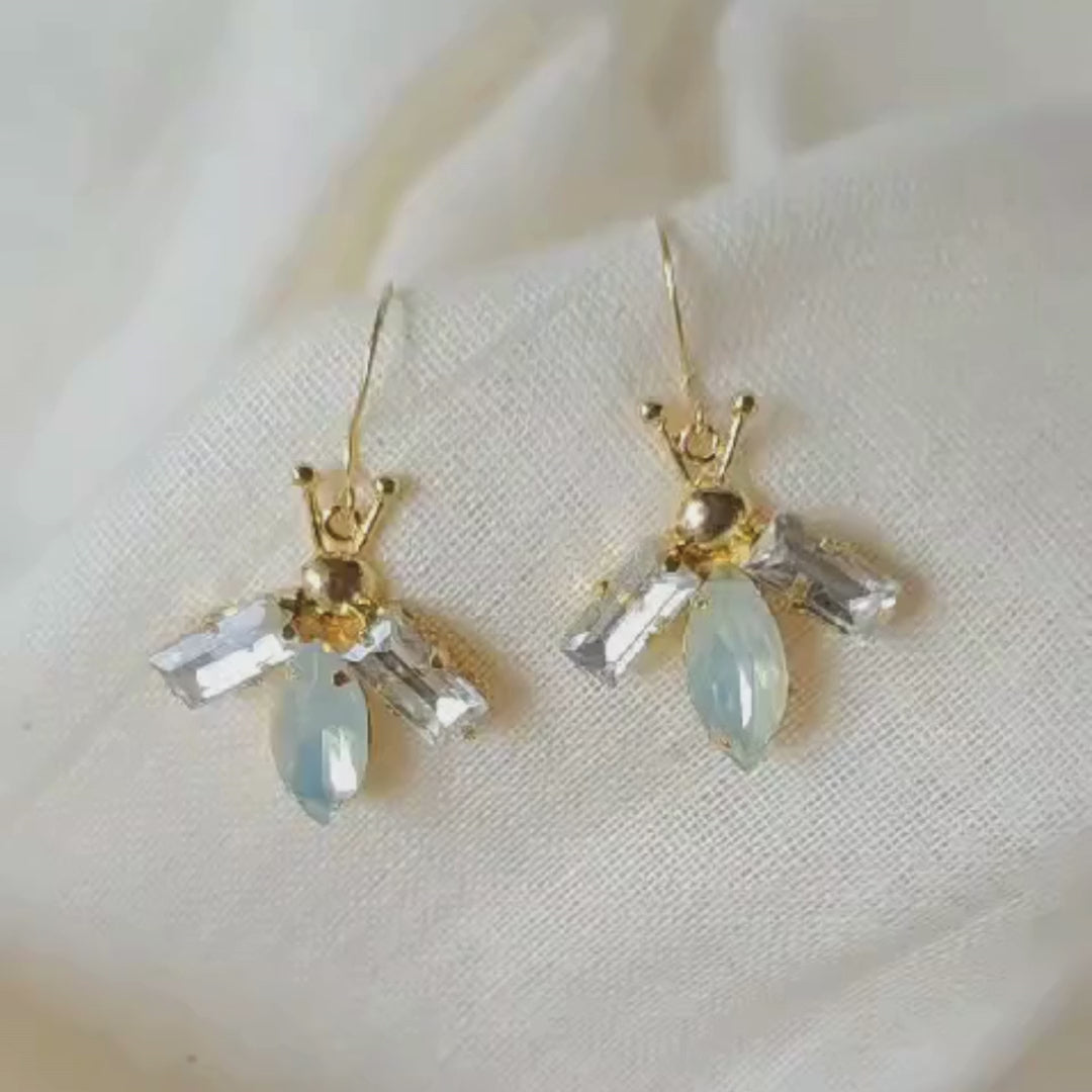 Lightweight bug-inspired earrings with brass, faux opal accents and 18K rhodium gold-plated 