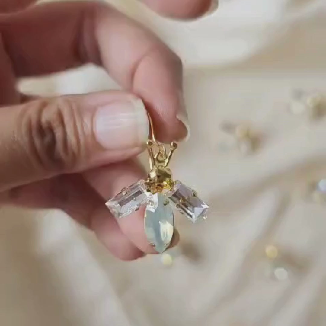 Lightweight bug-inspired earrings with brass, faux opal accents and 18K rhodium gold-plated 